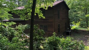 A rustic cabin surrounded by dense forest. - Charming 2-bedroom B&B in Honey Brook with WiFi, fitness room 
bed and breakfast (Honey Brook)