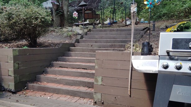 A wooden staircase leading up to a cabin in a forested area, with a grill and a bird feeder nearby. - Charming 2-bedroom B&B in Honey Brook with WiFi, fitness room 
bed and breakfast (Honey Brook)