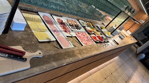 A buffet with various food items and utensils.