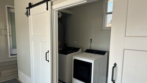A laundry room with a washing machine, dryer, and a small window. - Charming newly remodeled 3-bedroom house in the heart of Cleveland Tennessee (Cleveland)