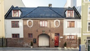 A two-story building with a brick facade, a red door, and a white garage door.