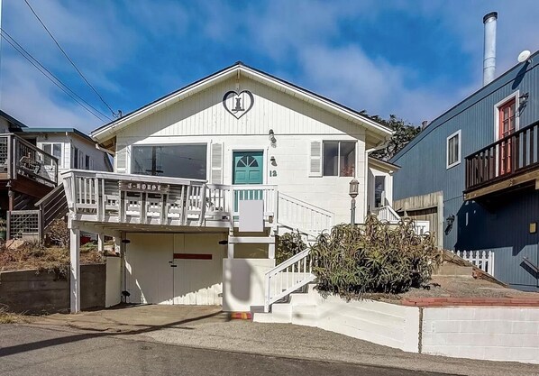 A two-story house with a white exterior, a green door, and a balcony. - Sea House Dillon Beach - 2 Bed, 1 Bath - 5 Minute Walk To Beach (Dillon Beach)