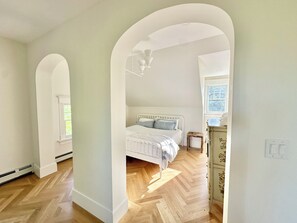 Ein Schlafzimmer mit einem Bett, einem Schminktisch und einem Fenster.
