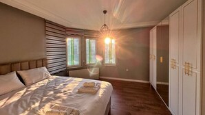 Un dormitorio con una cama grande, un armario y una ventana con persianas.