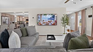 Un salon moderne avec un canapé gris, une table basse et un ventilateur de plafond.