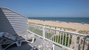 Een balkon met uitzicht op een strand en de oceaan.