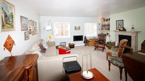 A living room with a sofa, armchairs, a coffee table, a fireplace, and a bookshelf. - beautiful central London duplex apartment007 (London)