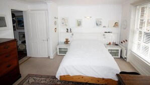A bedroom with a bed, dresser, and a small table with a teddy bear. There are framed pictures on the wall and a window with blinds. - beautiful central London duplex apartment007 (London)
