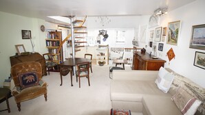 A spacious living room with a sofa, armchairs, a dining table, and a bookshelf. - beautiful central London duplex apartment007 (London)