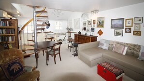 A spacious living room with a staircase, a sofa, a dining table, and a bookshelf. - beautiful central London duplex apartment007 (London)