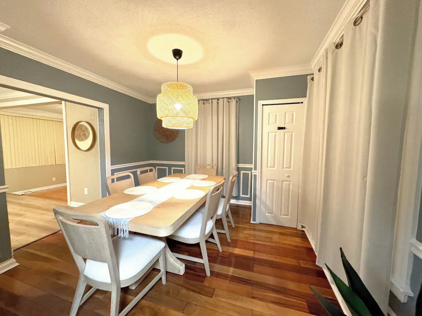A dining area with a wooden table, white chairs, and a hanging light fixture. - 2B1BA  Central - Airport, Riverside, Zoo, Beach (Jacksonville)