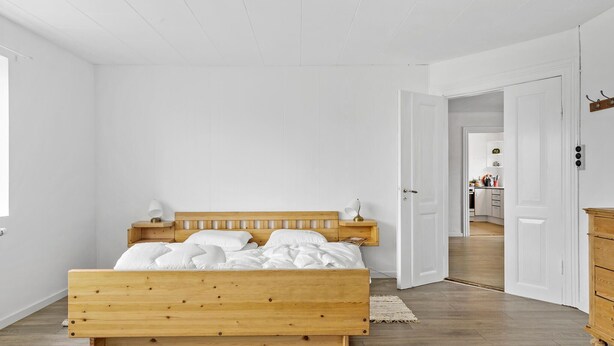 A bedroom with a wooden bed, white walls, and a wooden floor. - 4 bedroom nice home in Harboøre (Harboøre)