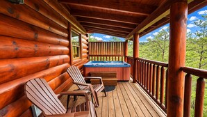Eine Holzterrasse mit Adirondack-Stühlen und einem Whirlpool.