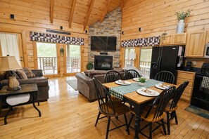 A cozy cabin with a dining area, sofa, and kitchen.