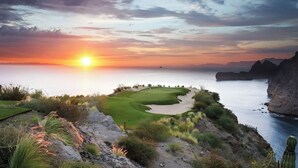 Un campo de golf con vistas al océano y acantilados al atardecer.