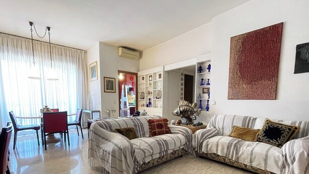 A living room with a sofa, a dining table with chairs, and a bookshelf. - di Alfredo (Roma)