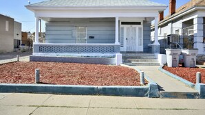 A single-story house with a grey roof, white exterior walls, and a front porch. - Entire Home Near UTEP  (El Paso)