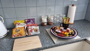 A kitchen counter with various food items and kitchenware.