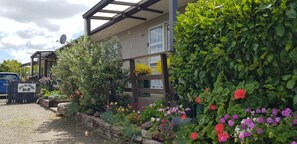 A building with a garden area, a wooden fence, and a sign that reads "One on Vogel B&B". - One on Vogel. (Woodville)