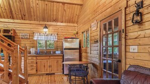 L’intérieur d’un chalet en bois comprend une cuisine, un coin repas et un espace salon confortable.