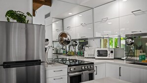 Een moderne keuken met roestvrijstalen apparatuur, witte kasten en een centraal eiland.