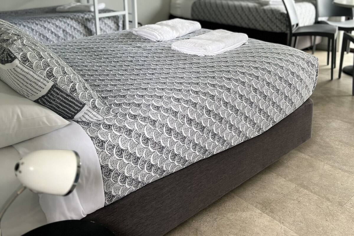 Ein modernes Schlafzimmer mit einem großen Bett, einem Nachttisch und einem Sessel.