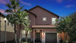 A two-story house with a brown facade, a tiled roof, and a front garage door. - Experience Solterra: Pool, Spa, Game Room & Lazy River (Davenport)