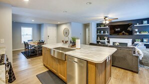 A modern kitchen with a central island, wooden cabinets, and stainless steel appliances. - Pine River Ranch-17 Acre Outdoor Paradise in the heart of the Manistee Forest (Wellston)