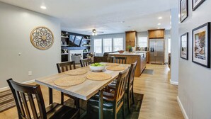 A modern kitchen with wooden cabinets, a built-in oven, and a refrigerator. - Pine River Ranch-17 Acre Outdoor Paradise in the heart of the Manistee Forest (Wellston)