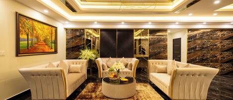 A modern living room with two sofas, a coffee table, and a painting on the wall.