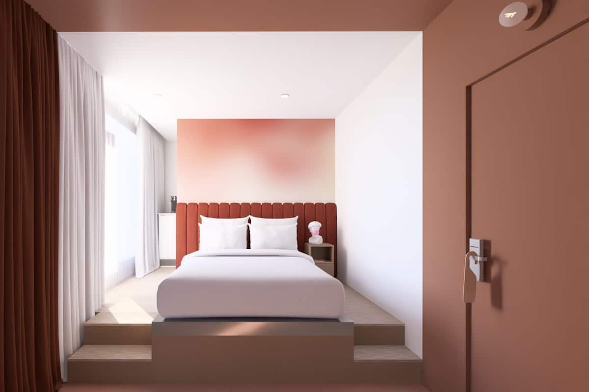 A modern hotel room with a large bed, a nightstand, and a view of the city.