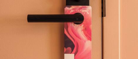 Una puerta con un picaporte negro y una tarjeta con la palabra 'ROSE'.