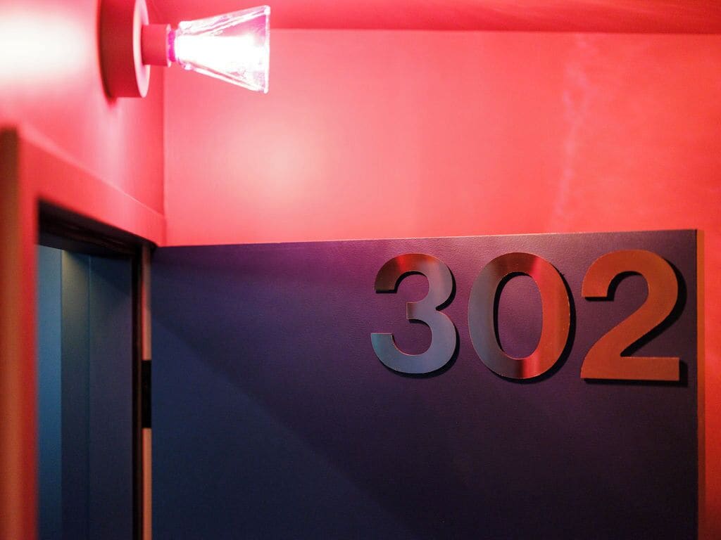 Pared con el número '302' en letras metálicas.