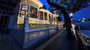 A historic building with ornate architecture, a balcony, and a tree in the foreground. - The Victorian Hotel CR (San José)