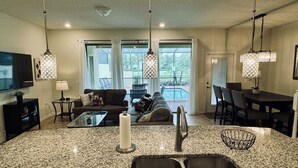 A modern kitchen with granite countertops, a stainless steel sink, and pendant lights. - Spacious 5-bedroom townhome in gated community. Minutes from Disney! Sleeps 10 (Davenport)
