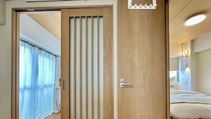 Ein Schlafzimmer mit Holztür, einem Bett und einem Nachttisch.