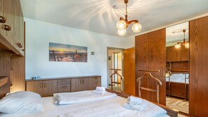 A hotel room with two beds, wooden furniture, a painting, and a ceiling light fixture. - Zeitlos by Interhome (Reifnitz)