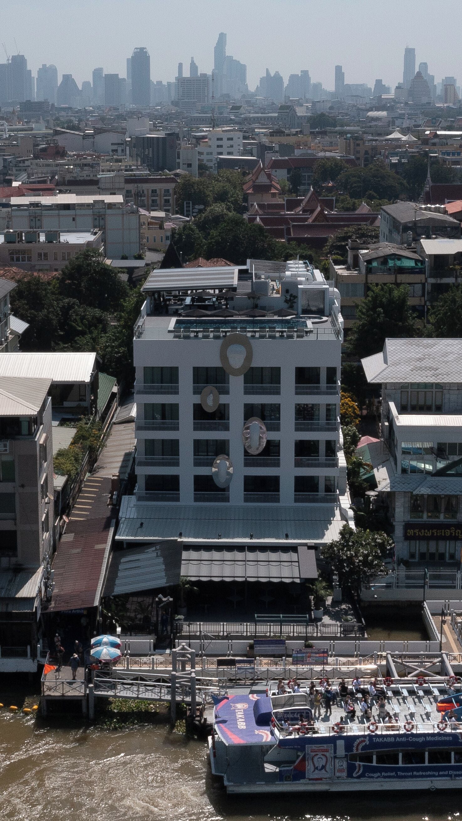 A multi-story building with a central courtyard, surrounded by other buildings.