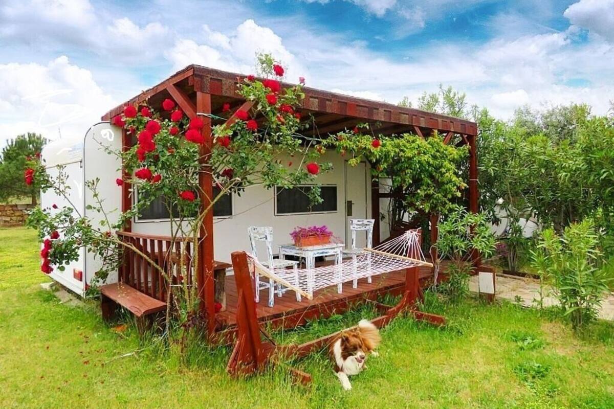 Ein kleines Haus mit Veranda, einem Esstisch und Stühlen.