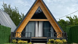 Un bâtiment moderne de forme triangulaire, avec un chemin de pierre menant à l’entrée.