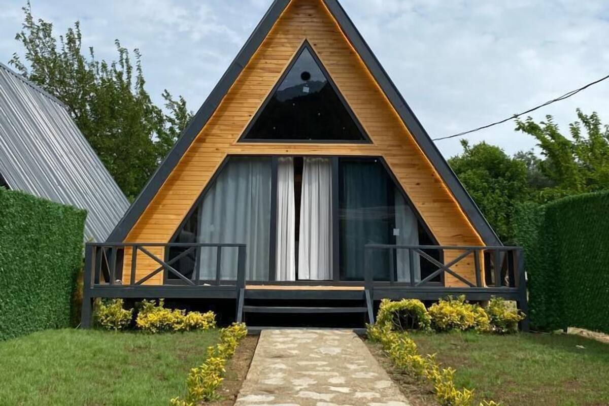 Ein modernes, dreieckiges Gebäude mit einem Steinweg, der zum Eingang führt.