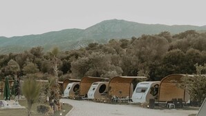 Une rangée de logements de style caravane, avec une chaîne de montagnes en arrière-plan.