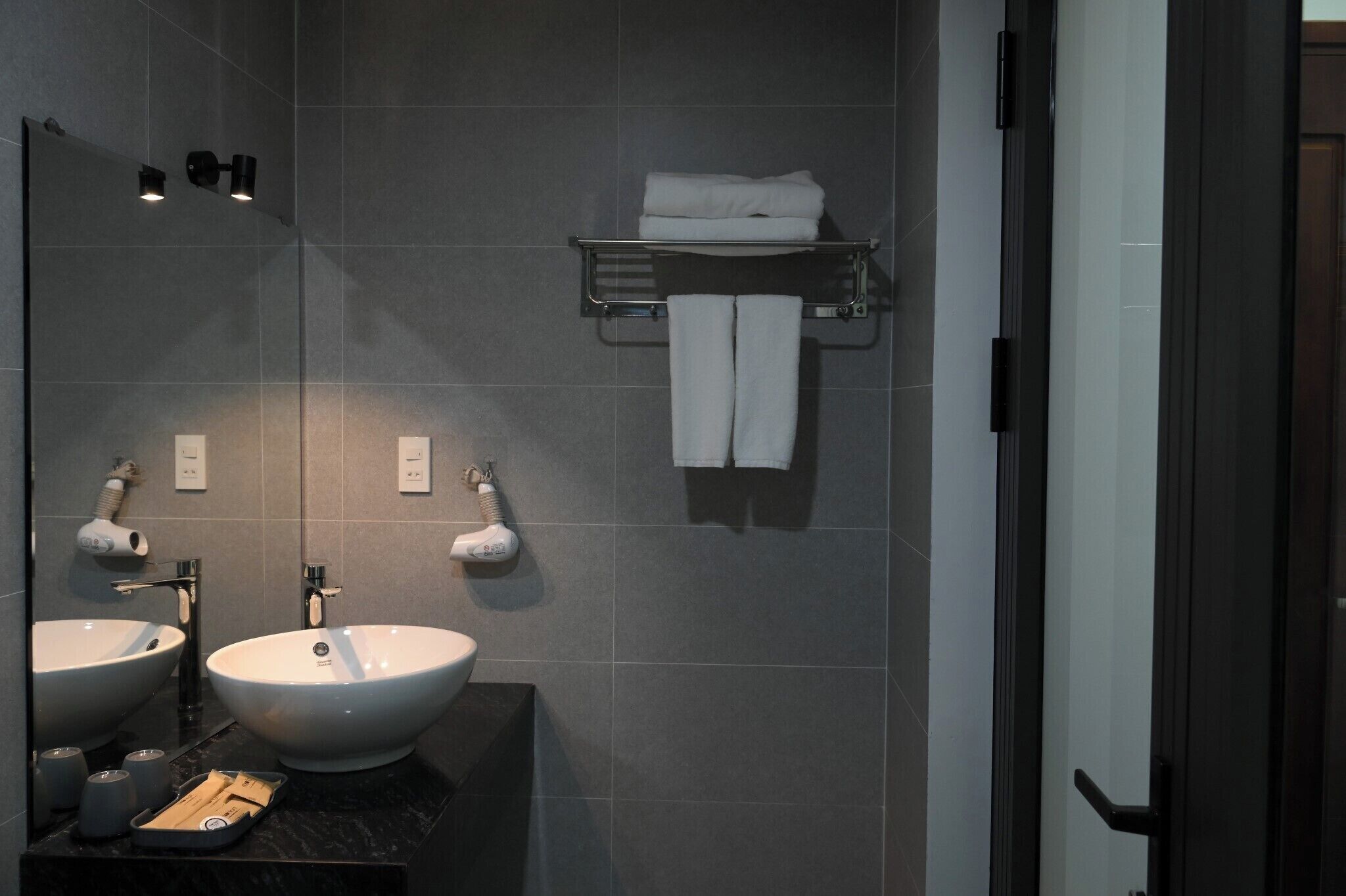 Une salle de bain moderne avec deux lavabos, un porte-serviettes et un miroir.