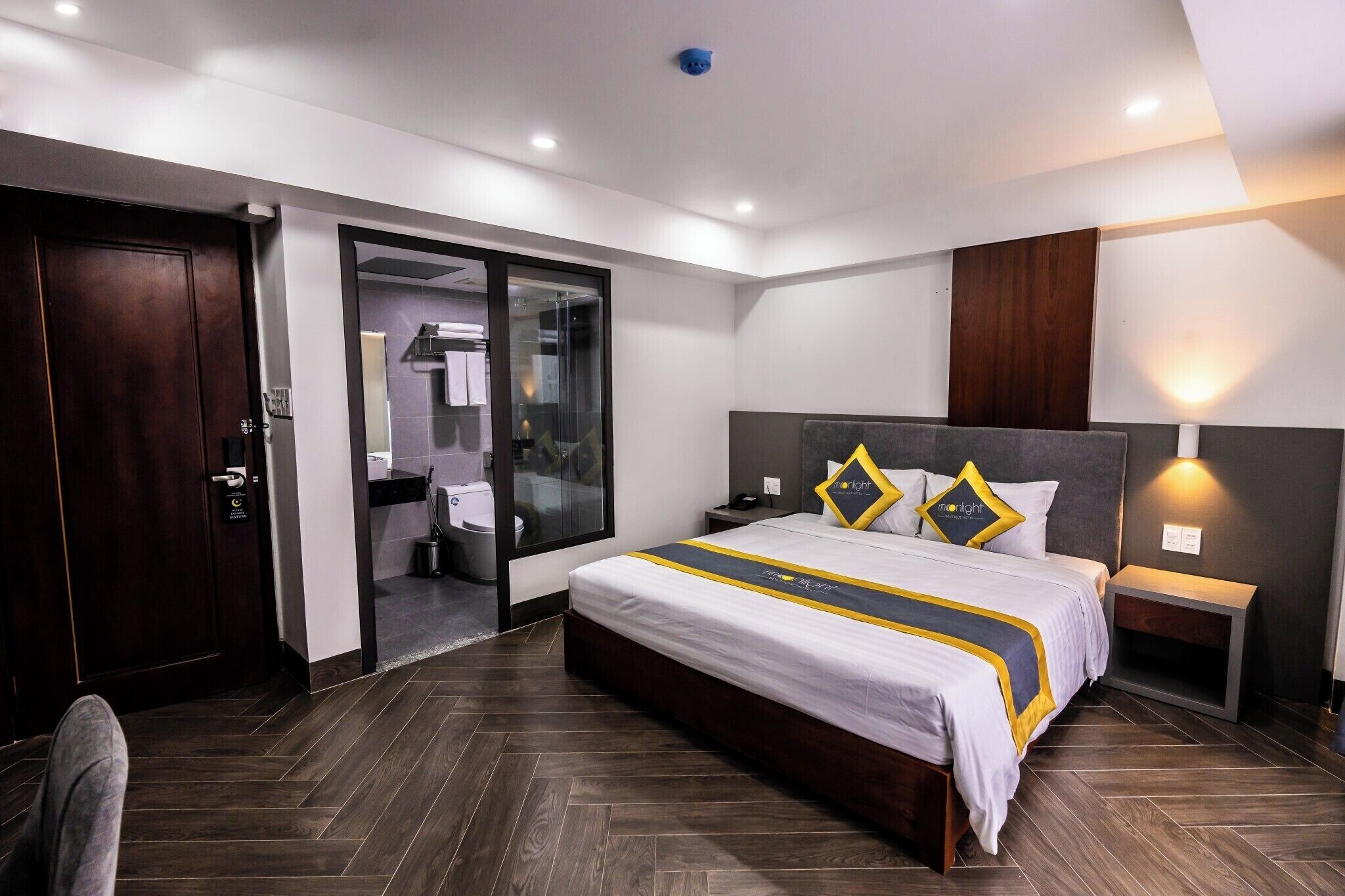 Ein modernes Hotelzimmer mit einem großen Bett, einem Schrank, einem Badezimmer und einem Schiebetürenschrank.