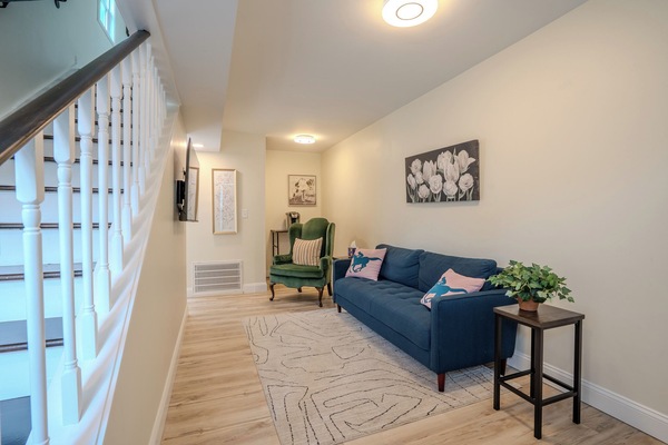 Living room with smart TV, couch and arm chair