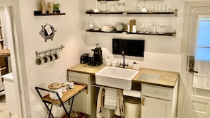 Kitchen area with sink, coffee maker, and utensils, perfect for cooking and dining.