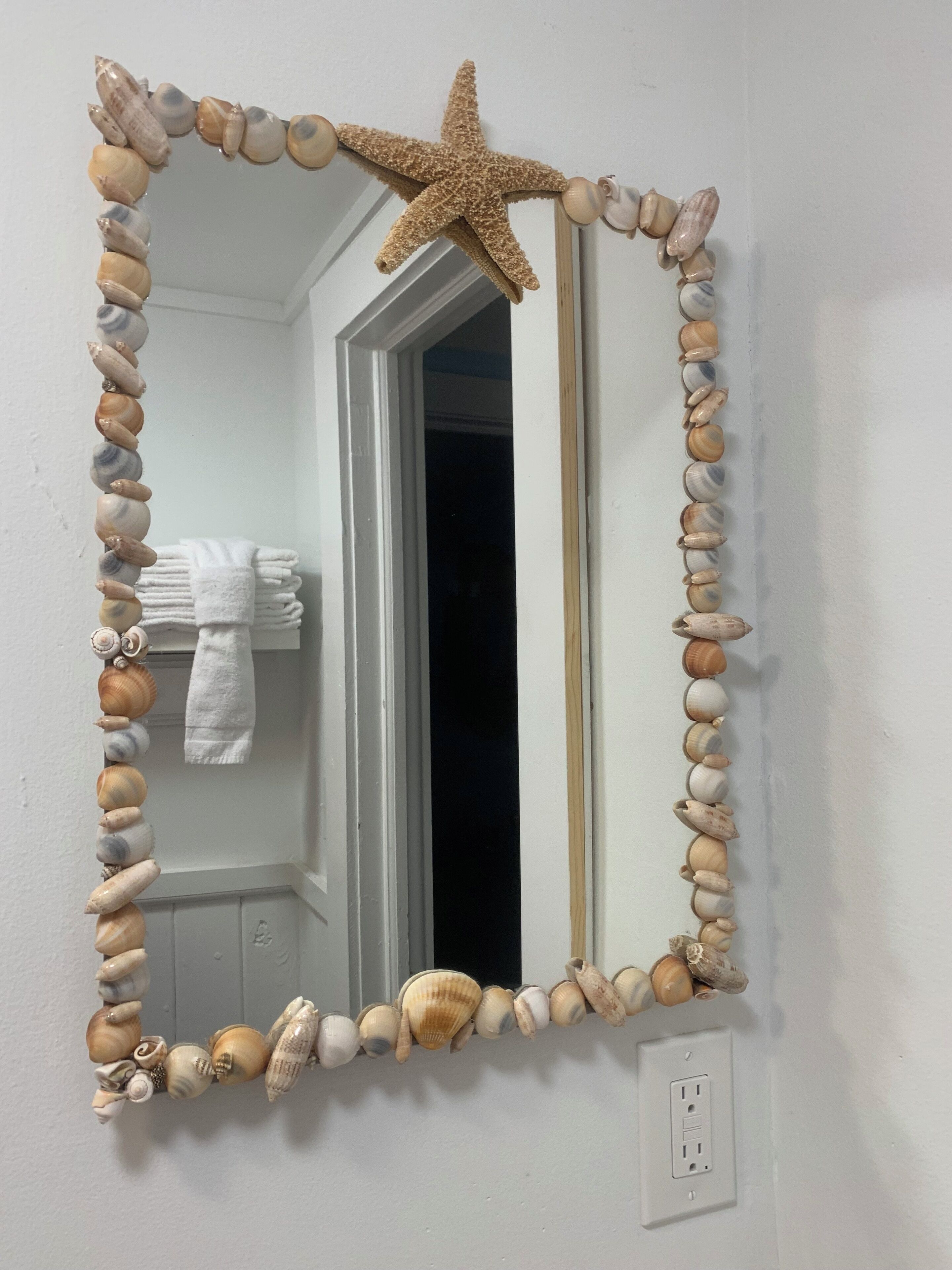 Un mirall amb decoració d'estrella de mar i vora de petxina.