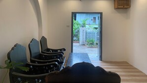 A conference room with a long table and several chairs, a door leading outside, and a ceiling light fixture. - La nuit de Laos (Luang Prabang)