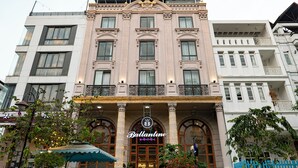 A hotel with a classic facade, large arched windows, and a prominent entrance with a sign.