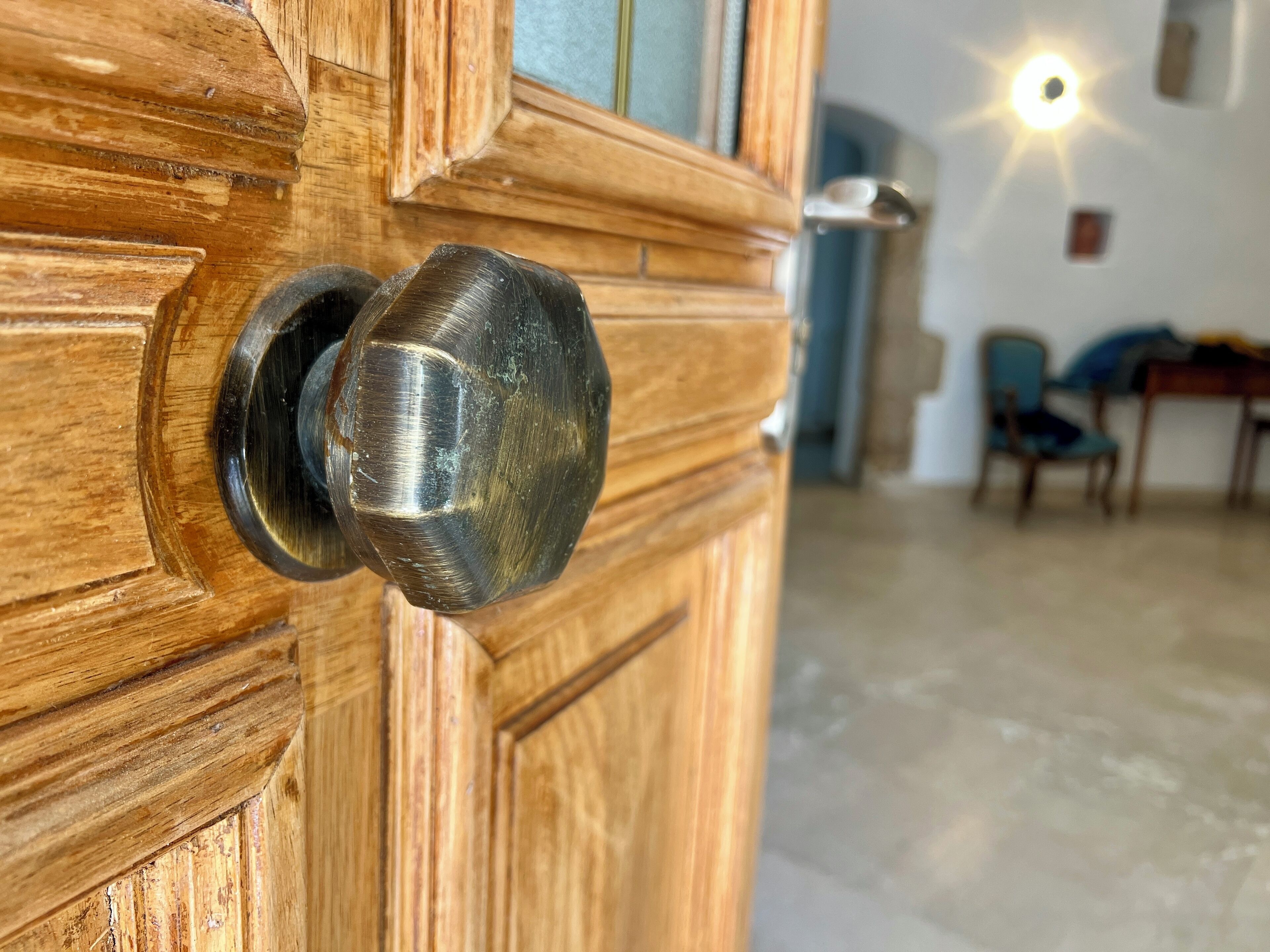 Een houten deur met een ronde, metalen deurklink.
